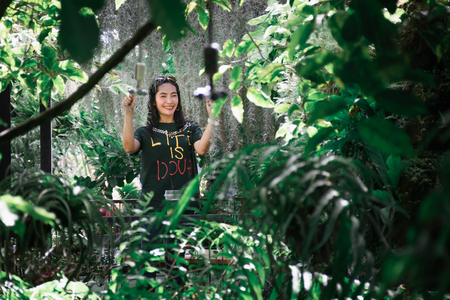 Lady fefreshing drink iced coffee on the table in the forest greenの写真素材