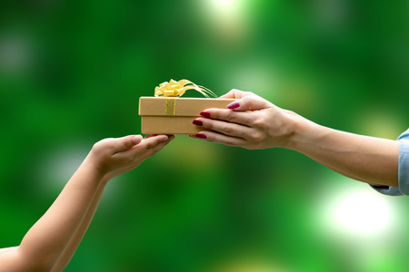 Hands Give a gift congratulation Thank You green backgroundの写真素材