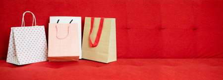 Paper bag shopping on the red sofaの写真素材