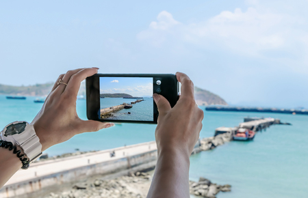 Mobile phone Smartphone, taking pictures of sea and mountain viewsの写真素材