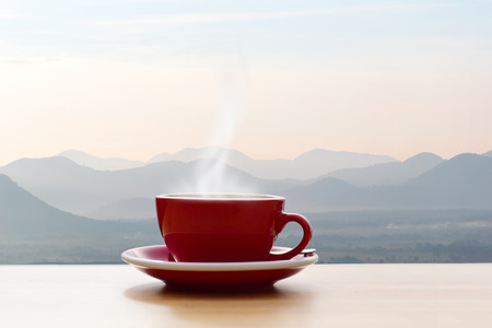 Coffee cup red with morning sunshine mountain viewの写真素材