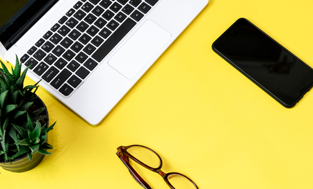 Laptop placed on a yellow table background of business working place with cup coffee, Empty workspaceの写真素材