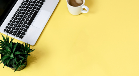 Laptop placed on a yellow table background of business working place with cup coffee, Empty workspaceの写真素材