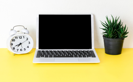 Laptop placed on a yellow table background of business working place with cup coffee, Empty workspaceの写真素材