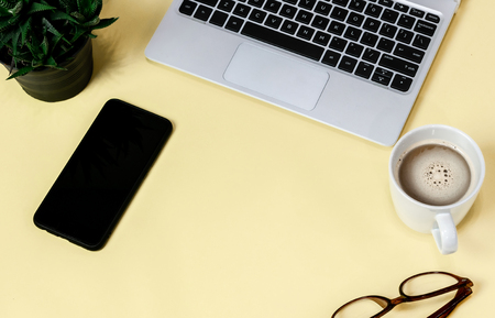 Laptop placed on a yellow table background of business working place with cup coffee, Empty workspaceの写真素材