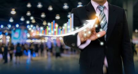 businessman pointing graph and arrow concept development to success growing annual revenue growthの写真素材