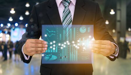 Businessmen hold the screen and investment graphs financial technologyの写真素材