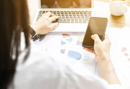 Women analyze graphs and charts financial profits from businessの写真素材