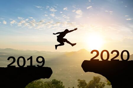 Happy New Year 2020 Men jump over silhouette mountains sunの写真素材