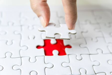 Fill the missing parts fragment of white jigsaw concept puzzle for succeedの写真素材