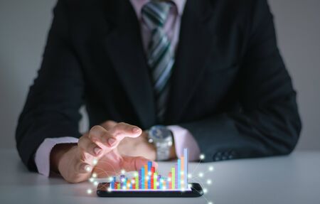 Business man show financial stock growth concept technology and graph display on smartphoneの写真素材
