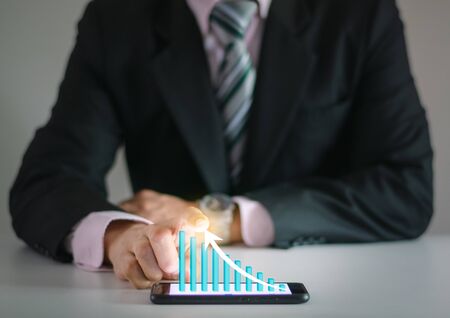 Business man show financial stock growth concept technology and graph display on smartphoneの写真素材