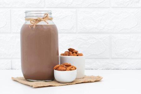 Milk Chocolate and Almonds in a glass on a white backgroundの写真素材