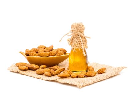 Honey jar and almonds on a white backgroundの写真素材