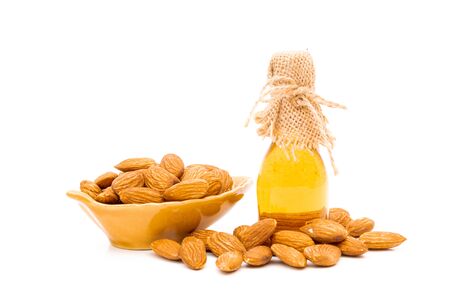 Honey jar and almonds on a white backgroundの写真素材