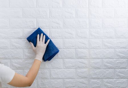 Women wearing gloves to wipe the table to clean the dustの写真素材