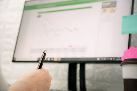 The hand pen of a businesswoman is working with a computerの写真素材