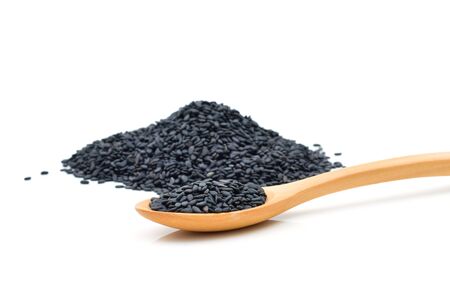 Black sesame seeds in wooden scoop on white backgroundの写真素材
