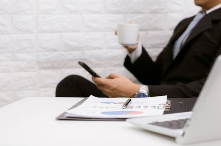Coffee break businessman executive working relax on laptop at his desk.の写真素材