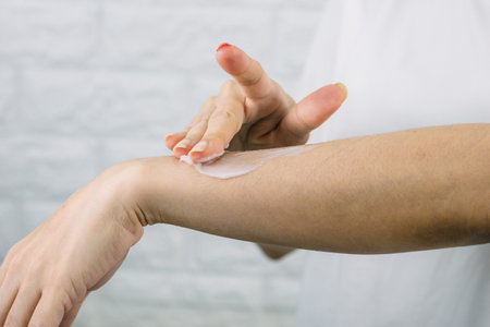 A woman applying a skin care cream arm