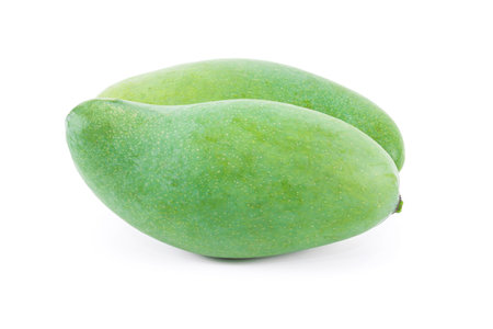 A raw mango fruit on a white backgroundの写真素材