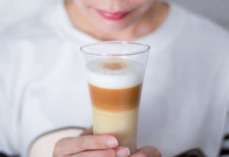 Woman holding a cup Coffee latte milk froth the hot drinkの写真素材