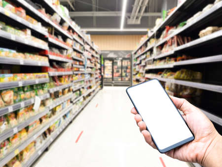 hand hold smartphone white screen blur shopping mall backgroundの写真素材