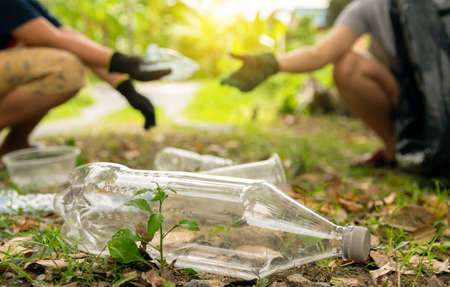 Human hand collect plastic waste in trash bags for the environment