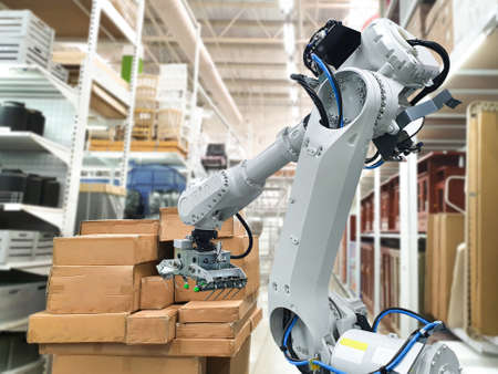 Industrial robotic arm loading carton for holding a packageの写真素材