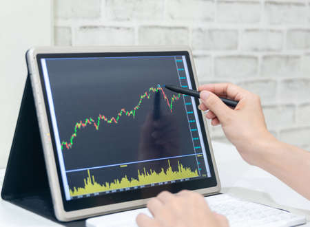 A business examines the financial graph of sales growth on the computerの写真素材