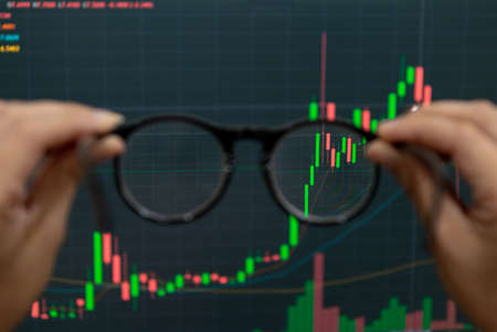 Hand holding glasses trade financial stocks and investmentsの写真素材
