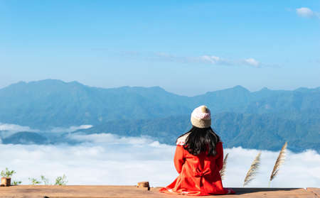 woman sitting and watching fog and mountains travel empty space