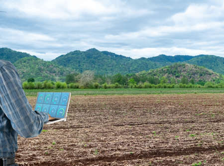 Farmers use computers to prepare soil for planting.の写真素材