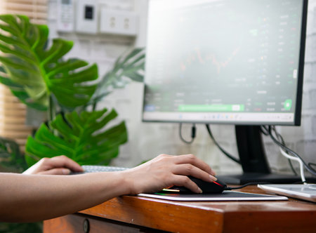 Woman analyzing graphs in progress money on the table doing workの写真素材