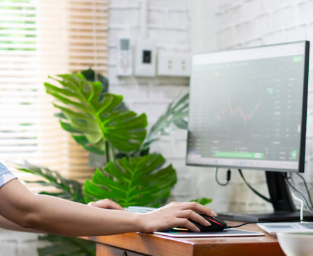 Woman analyzing graphs in progress money on the table doing workの写真素材