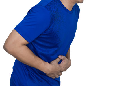 A man has a stomachache and holds his stomach with his hand.の写真素材