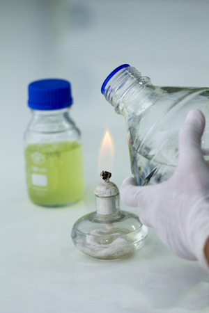 Close-up of bottle being sterilized with an alcohol burner before use in marine plankton culture in Scientific laboratoryの写真素材