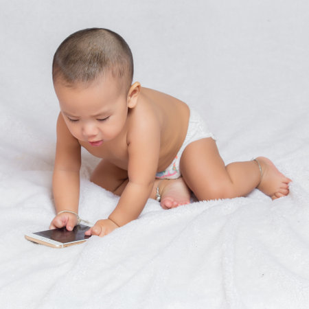 Happy baby wearing red t-shirt.Cute kids in a good mood Sit down on the couchの写真素材