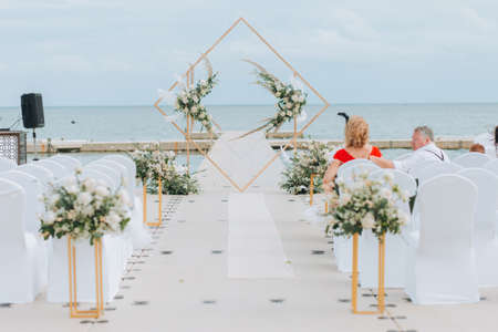 Wedding on the beach .Beach wedding venue setting on the white sand with beautiful panoramic ocean view background, Pink and red rose petals on the aisleの写真素材