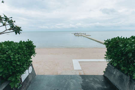 Wedding on the beach .Beach wedding venue setting on the white sand with beautiful panoramic ocean view background, Pink and red rose petals on the aisleの写真素材