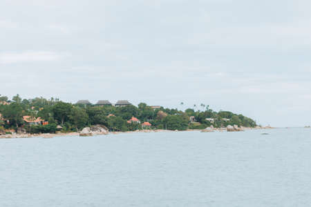 Wedding on the beach .Beach wedding venue setting on the white sand with beautiful panoramic ocean view background, Pink and red rose petals on the aisleの写真素材