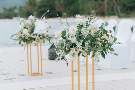 Wedding on the beach .Beach wedding venue setting on the white sand with beautiful panoramic ocean view background, Pink and red rose petals on the aisleの写真素材