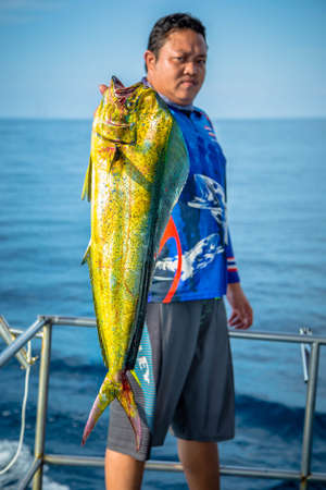 Lucky fisherman holding a beautiful dolphin fishの写真素材