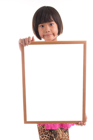 Little asian girl holding white board on white backgroundの写真素材