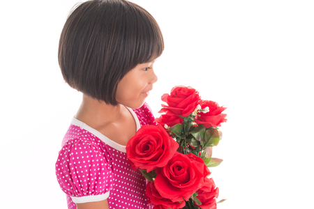 Little asian girl holding a rose on white backgroundの写真素材
