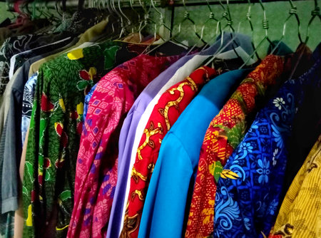 colorful clothes on hangers in a shop, closeup of photoの写真素材