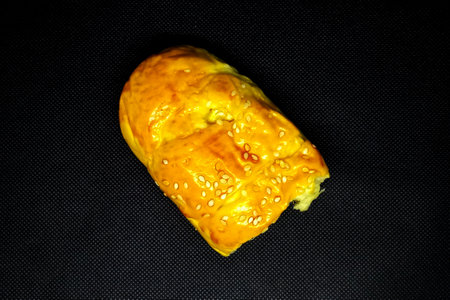 Bread with sesame seeds on a black background. Toned.の写真素材