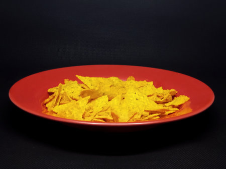 Mexican corn nachos on a red plate on a black backgroundの写真素材