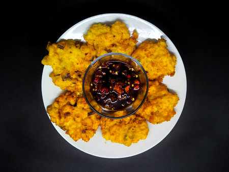 Crispy fried cauliflower with sweet and sour sauce on black backgroundの写真素材