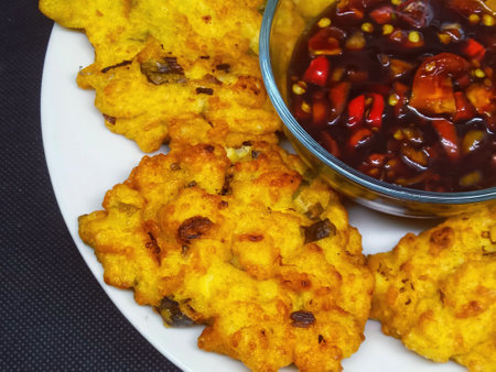 Crispy fried potato pancakes with chili sauce on black background.の写真素材